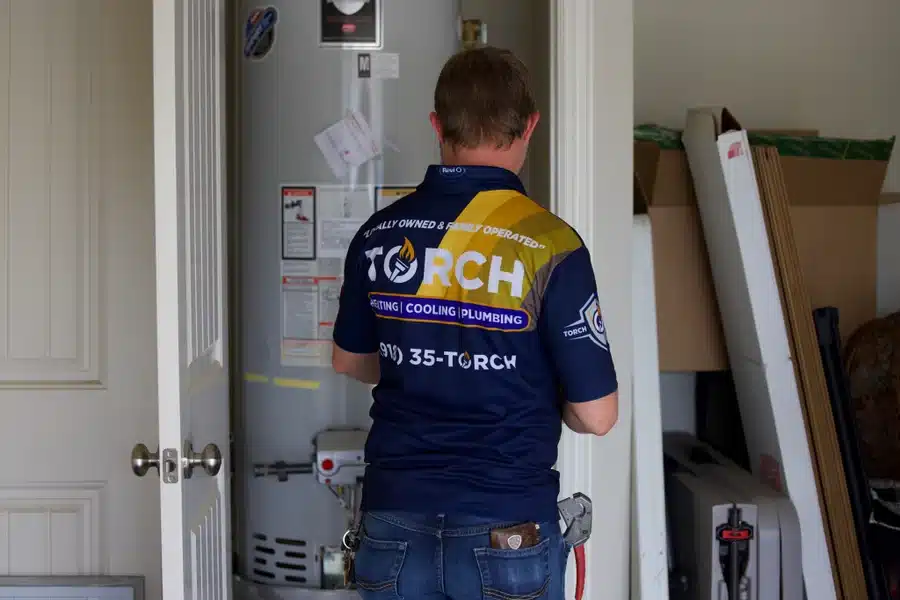 Torch technician servicing and installing a residential water heater